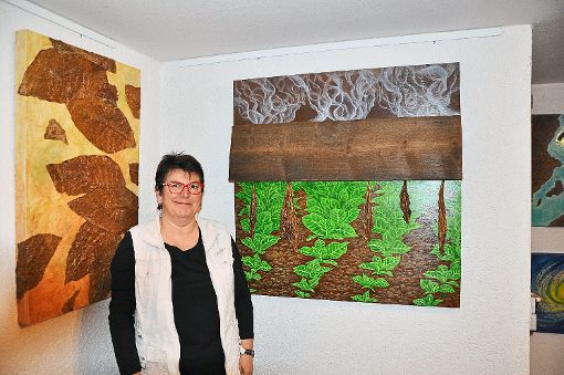 Katrin Oßwald in ihrem Atelier in Altenheim vor ihrem Lieblingswerk (rechts): Zu sehen ist darauf der Verarbeitungsweg der Tabakpflanze.   Foto: Werner
