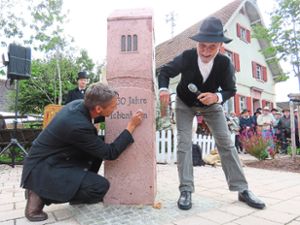 950 Jahre Ichenheim: Am Jubiläumsstein setzt Ortsvorsteher Ralf Wollenbär einen i-Punkt, im Hintergrund beobachtet Bürgermeister Jochen  Fischer an der Drehorgel das Geschehen.  Foto: Bohnert-Seidel