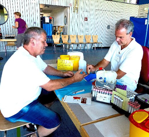 Klaus Link (links), der zum 70. Mal Blut spendete, wird von Michael Groß vom DRK-Blutspendedienst versorgt. Foto: Fink Foto: Lahrer Zeitung