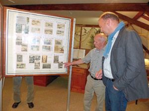 Max Walter (links) zeigt Neurieds Bürgermeister Jochen Fischer seine Postkarten-Ausstellung bei der Vernissage im Heimatmuseum Altenheim.  Foto: Fink