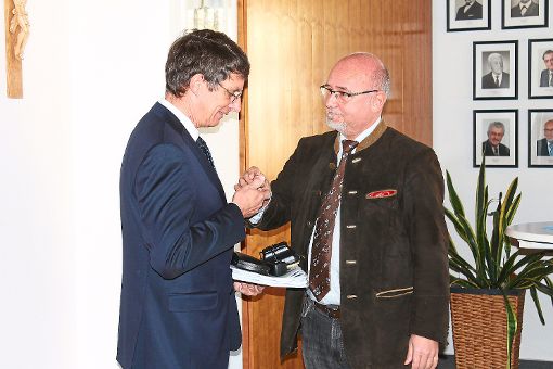 Armin Schwarz (rechts) übergibt seinem Nachfolger Thomas Schneider wichtige Unterlagen, die Amtskette und vier Schlüssel. Foto: Störr