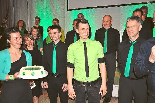 Die Sänger bedankten sich bei Dirigent Simon Göppert (im grünen Hemd) mit einer Torte.  Foto: Schwab