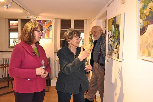 Die Freiburger Künstlerin Lizzi Zebisch (Mitte) erklärt Regine Staudenmeyer-Türck, wie das Gemälde – eines ihrer ersten Werke – entstanden ist. Ihr guter Freund Kurt Bildstein (rechts) war den ganzen Abend mit dabei.   Foto: Werner