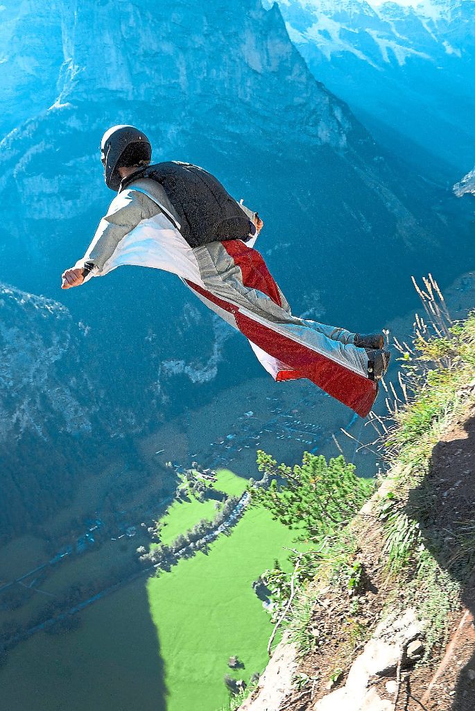 Susanne Böhme springt hier  mit dem Wingsuit von einem Felsen in den Alpen ab, gleitet in der Luft und öffnet zur Landung rechtzeitig den mitgeführten Fallschirm.