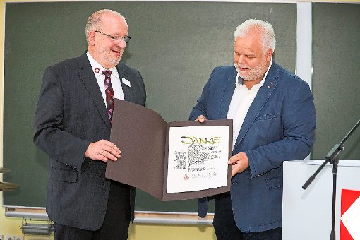 Schulleiter Ralf Dyck (links) erhält von Frank Berenbrinker, stellvertretender Bundesinnungsmeister, eine Urkunde.  Foto: Breuer