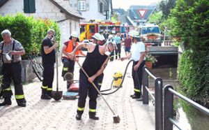 Einsatz unter Atemschutz: Die Feuerwehr entfernte die Reste des Chlorgranulats, das auch auf dem Gehweg neben dem Altdorfer Dorfbach zu finden war.   Foto: Künstle