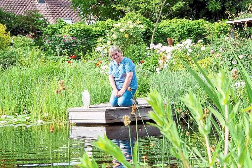 Die Freude über ihren Traumgarten samt Teich ist Gabriele Jerger anzusehen. In dem Gewässer schwimmt sie regelmäßig.   Foto: Breuer
