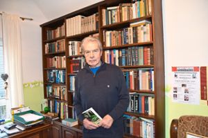 Hans Weide mit seinem Roman in der hauseigenen Bibliothek  Foto: Werr