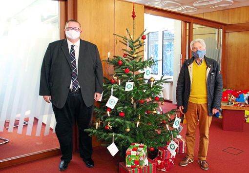 Stephan Schmieder von der Sparkasse (links) und Helmut Patzelt von der Nachbarschaftshilfe haben den Weihnachtsbaum mit den Geschenkwünschen aufgestellt.   Foto: Kiryakova