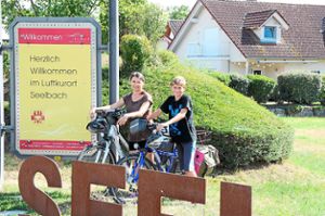 Nils und Nicole Himmelsbach vor dem Eingang von Seelbach, der vorletzten Station ihrer Radtour nach Dörlinbach, wo die Urgroßmutter des zwölfjährigen Jungen wohnt. Foto: Kiryakova