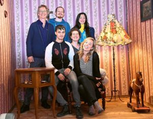 Autor und Regisseur Edzard Schoppmann (links) sitzt mit einigen Mitgliedern des Ensembles im mobilen Theater in den Kulissen der Heimatrevue aus den Fünfziger Jahren. Foto: Achnitz