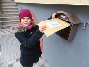 Hannah Groß wirft  ihr erstes Kuvert in den Briefkasten in Oberweier. Foto: Bohnert-Seidel