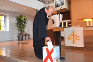 Auch Dekan Rainer Becker warf am Sonntag seinen Stimmzettel in die Urne vor dem Altar.   Foto: Bühler