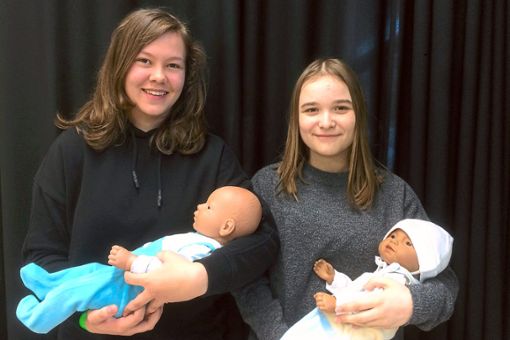 Liana Hofmann (links) und Angelina Petri   mit ihren Babysimulatoren Johannes und Pedro Foto: Caritasverband