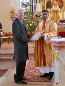 Für seine 60-jährige Zugehörigkeit zum Kirchenchor bekam Manfred Krieg eine Urkunde von Pater Vigil Anto. Foto:  Meier