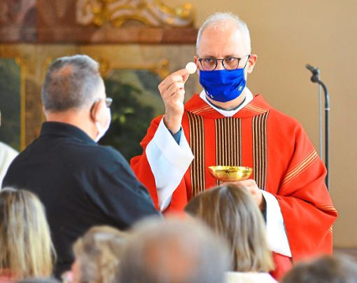 Ebenso wie die Besucher trug Pfarrer Johannes Mette beim Empfang der Heiligen Kommunion eine Maske. Foto: Axel Dach