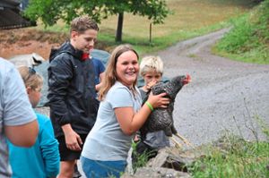 Mathilda freut sich darüber, das Huhn tragen zu dürfen. Damit die Tiere aber nicht zu sehr gestresst werden, dürfen sie nach kurzer Zeit schon ins Gehege zurück. Foto: Lübke