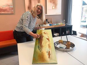 Bernadette Vögele bei der Arbeit in ihrem Atelier in der Kirchstraße. Das Bild, eine Auftragsarbeit für einen Kunden, entsteht  aus Marmormehl und Kurkuma. Foto: Lübke