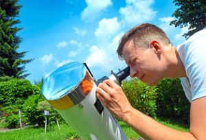 Rico Dach mit seinem Spiegelteleskop: Zum Schutz der Augen hat er einen Sonnenfilter installiert. Foto: Axel Dach