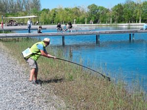 René Wehrle vom LGS-Helferkreis drehte am Sonntag mehrere Runden um den LGS-See, um den Uferbereich zu säubern. Hier fischt er eine leere Plastikflasche aus dem Wasser. Foto: Schabel