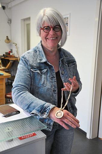 Friederike Hüffner zeigt eins ihrer selbst entworfenen und gefertigten Schmuckstücke: Eine Elfenbeinrose mit Horn-Elementen. Bei meinen Anfertigungen hatte ich immer den Anspruch, dass ich sie selbst tragen würde, sagt die Goldschmiedin.  Foto: Kleinberger Foto: Schwarzwälder Bote