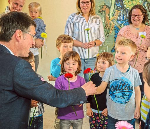 Blumen von der Blumenwiese: Bürgermeister Jochen Paleit freute sich mit den Kindern über die Kita-Eröffnung.  Foto: dec