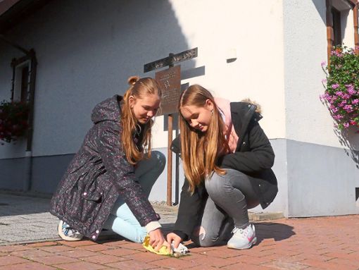 Die Schülerinnen Leonie und Maria  polieren den Stolperstein in der Lahrgasse. Dort stand einst die Synagoge.Fotos: Bohnert-Seidel Foto: Lahrer Zeitung
