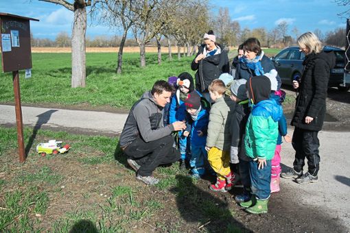 Der Auftakt des Projekts Kindergartenweizen: Landwirt Philipp Andlauer erklärt den Kindern die junge Pflanze. Foto: Masson