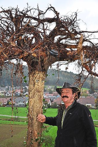 Herbert Moßmann stellt seine Holzfiguren auf den Kopf. So dienen die Wurzeln als Haare.  Foto: Schwab