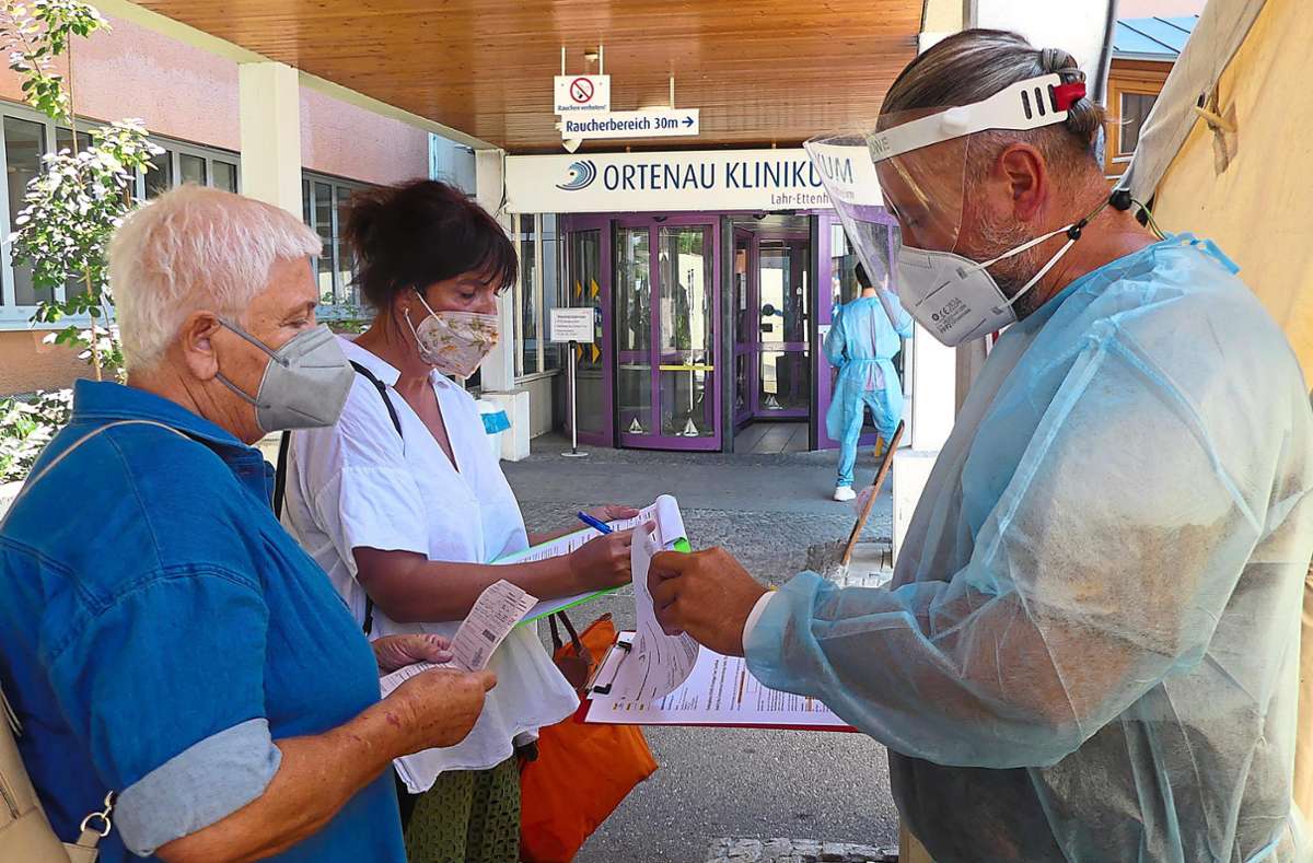 Tester Frank Gassmann (rechts) kümmert sich im die Unterlagen von Getesteten am Testzentrum Klinikum. Foto: Kapitel-Stietzel