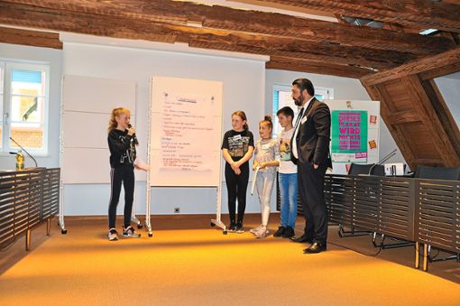 Lia Bechtold (von links), Larisa Pfaff, Lina Benz und Luca Benz präsentieren Bürgermeister Saar die Ergebnisse ihrer Arbeit. Foto: Schwarzwälder Bote