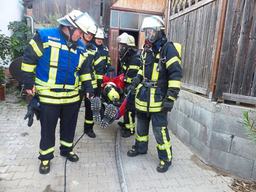 Der Sicherungstrupp rettet einen verletzten Kameraden aus dem brennenden Gebäude.   Foto: Fink